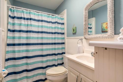 ein Badezimmer mit Waschbecken, Toilette und Spiegel in der Unterkunft You Are My Sunshine in Dauphin Island