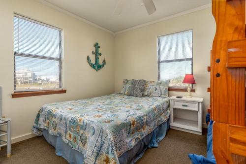 ein Schlafzimmer mit einem Bett und zwei Fenstern in der Unterkunft You Are My Sunshine in Dauphin Island