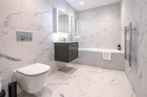 a white bathroom with a toilet and a sink at Premium CITY Apartment in Hemel Hempstead
