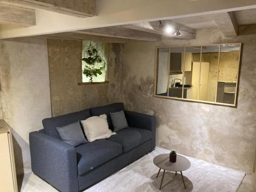 un salon avec un canapé bleu et une table dans l'établissement Le Discret - Un Voyage en Provence, à Aix-en-Provence