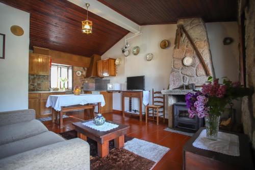 a living room with a couch and a table and a kitchen at Casa da Calçada in Sortelha