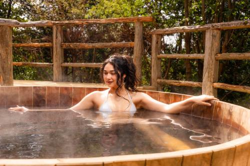 a woman is sitting in a hot tub at Hotel Parque Quilquico in Castro