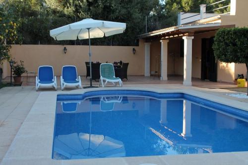a swimming pool with two chairs and an umbrella at Ideal for resting, hiking or biking in Sóller