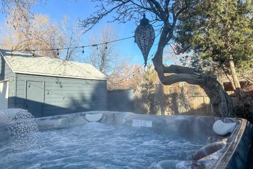 a snow covered yard with a tree and a building at Hot Tub, Fire Pit Midtown Reno Oasis! in Reno