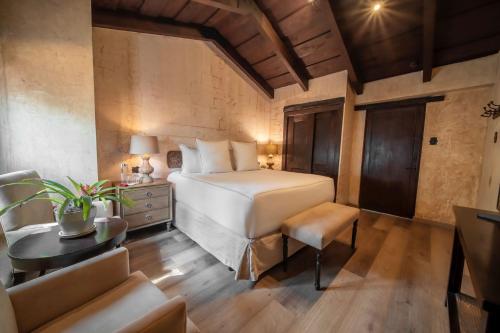 a bedroom with a bed and a table and a couch at El Convento Boutique Hotel in Antigua Guatemala