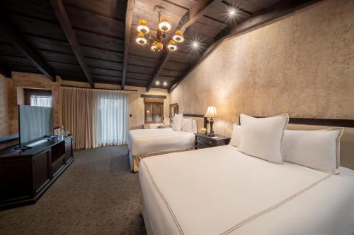a hotel room with a bed and a television at El Convento Boutique Hotel in Antigua Guatemala
