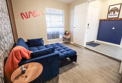 a living room with a blue couch and a table at 6S Hideout Houston in Cypress