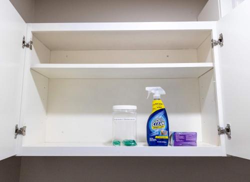a cupboard with cleaning products in it at 6S Hideout Houston in Cypress