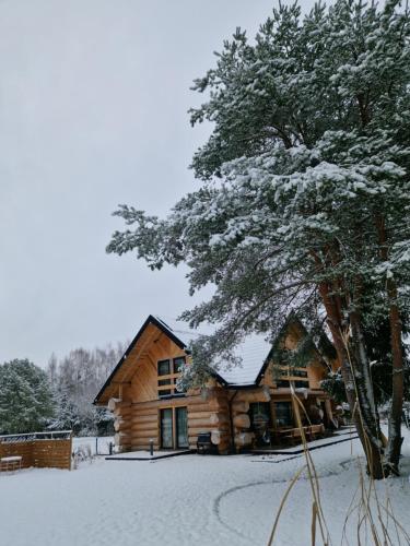 a log cabin in the snow with a tree at Chata Braci Warchały in Warchały