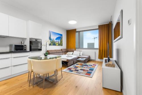 a kitchen and living room with a couch and a table at SKYPARK, Luxusný Apartmán s parkovaním vo výške in Nivy