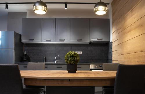 a kitchen with a wooden table with a potted plant on it at Zenith - Alpine Retreat in Zărneşti