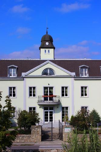 a large white building with a clock tower on top at Kaštieľ AGATKA in Chorvátský Grob