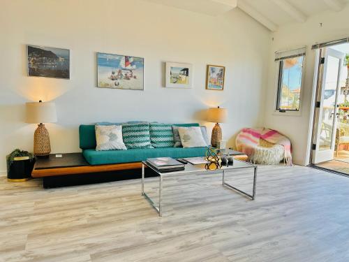 a living room with a blue couch and a table at Bright Avalon Villa W Ocean Views & Hot Tub in Avalon