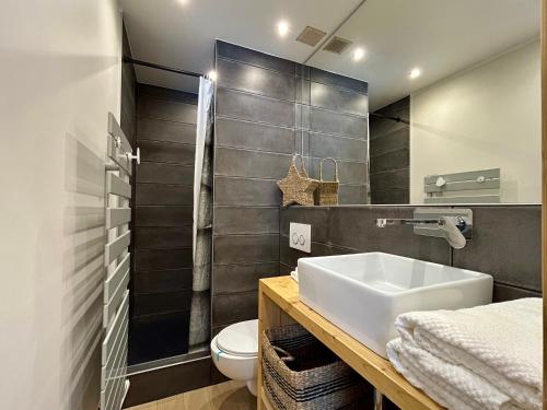 a bathroom with a sink and a toilet at Homency - Residence Signal C32 in L'Alpe-d'Huez