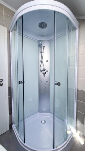 a shower with a glass enclosure in a bathroom at Zenith - Alpine Retreat in Zărneşti