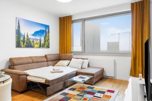 a living room with a couch and a large window at SKYPARK, Luxusný Apartmán s parkovaním vo výške in Nivy