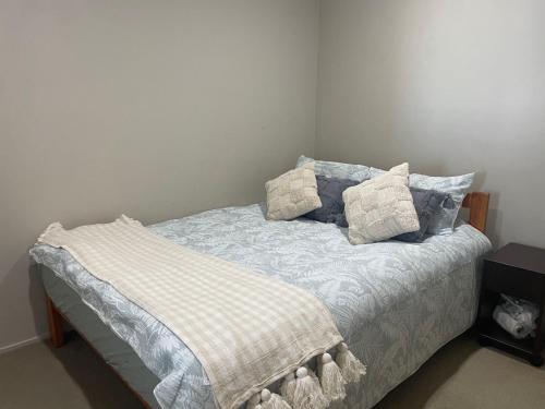 a bed with pillows on it in a room at AURA B two bedrooms, 1 living room Wi-Fi skytower and street view, balcony , easy parking in Auckland