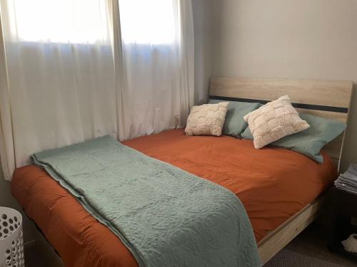 a bed with two pillows on it in a bedroom at AURA B two bedrooms, 1 living room Wi-Fi skytower and street view, balcony , easy parking in Auckland