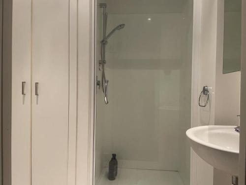a white bathroom with a shower and a sink at AURA B two bedrooms, 1 living room Wi-Fi skytower and street view, balcony , easy parking in Auckland