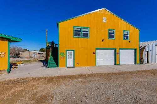 a large yellow building with two doors and a ramp at Near ATV Trails Carlsbad Apt with Shared Fire Pit in Carlsbad