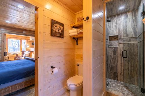 La salle de bains est pourvue d'une cabine en rondins, de toilettes et d'une douche. dans l'établissement Land Harbor Lodge, à Newland