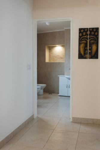 a bathroom with a toilet and a painting on the wall at Flor do Mar House in Ponta Delgada
