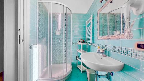 a blue bathroom with a sink and a shower at House Rene in Agerola