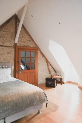 une chambre avec un lit dans un grenier dans l'établissement Magnifique maison au coeur du Perche avec piscine chauffée, sauna et hammam, à Grande Courbetière