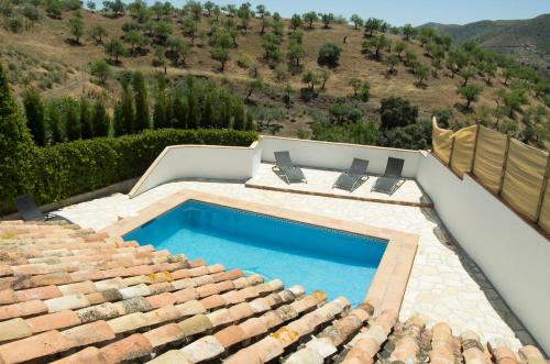 a swimming pool on the roof of a house at Rural Montes Málaga: Cortijo La Palma in Málaga