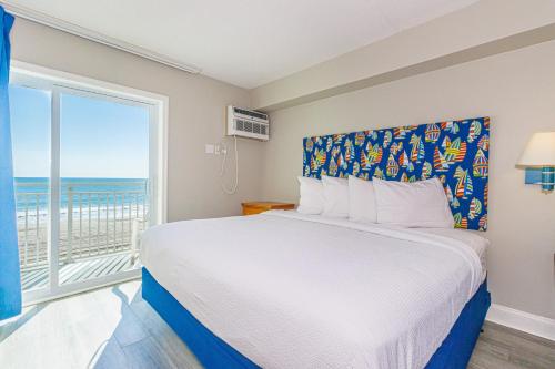 une chambre avec un lit et une grande fenêtre dans l'établissement Breath-taking Remodeled Oceanfront Studio! Sea Mist 20307, à Myrtle Beach