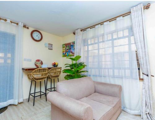 Una sala de estar con un sofá y una ventana. en Polea Hapa, en Ngong