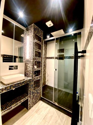 une salle de bain avec une douche en verre et un lavabo dans l'établissement Au Refuge du Matelot, au Crotoy