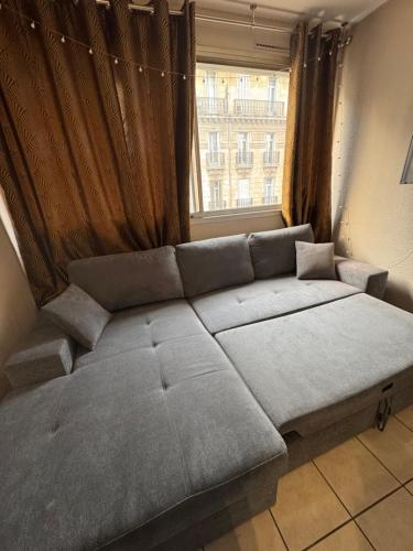 Cette chambre dispose d'un grand canapé et d'une fenêtre. dans l'établissement Studio Paradis, à Marseille
