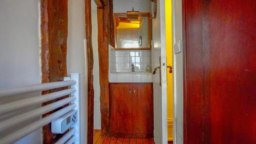 ein Badezimmer mit Waschbecken und Holztür in der Unterkunft 012 Grand studio at quartier latin in Paris