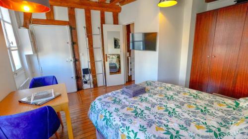ein Schlafzimmer mit einem Bett, einem Tisch und Stühlen in der Unterkunft 012 Grand studio at quartier latin in Paris