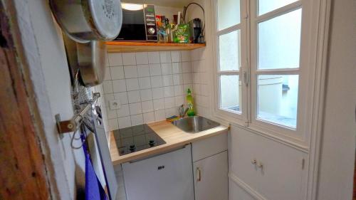 une petite cuisine avec un évier et une fenêtre dans l'établissement 012 Grand studio at quartier latin, à Paris