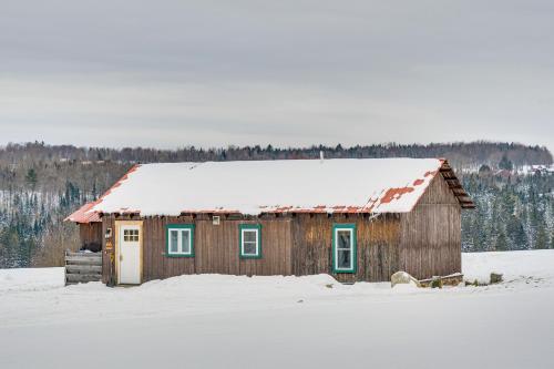 a small wooden house with snow on the roof at Ride From Your Door Cabin with VAST Trail Access! in Hardwick