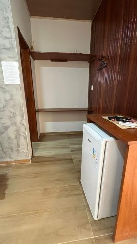 a kitchen with a white refrigerator and a counter at POUSADA IRMAOS ATINS in Atins