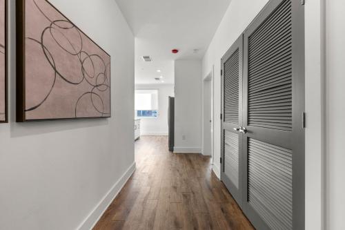 a hallway with white walls and wood floors and a door at The Nomad ATL in Atlanta