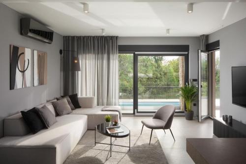 ein Wohnzimmer mit einem weißen Sofa und einem Fernseher in der Unterkunft Villa Anthea and Paola in Nedeščina