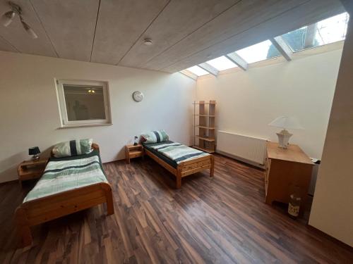 a large room with two beds and a window at Monteurwohnung-Ferienwohnung Aalen Westhausen in Westhausen