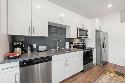 a kitchen with white cabinets and stainless steel appliances at The Nomad ATL in Atlanta