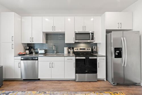 a kitchen with white cabinets and stainless steel appliances at The Nomad ATL in Atlanta