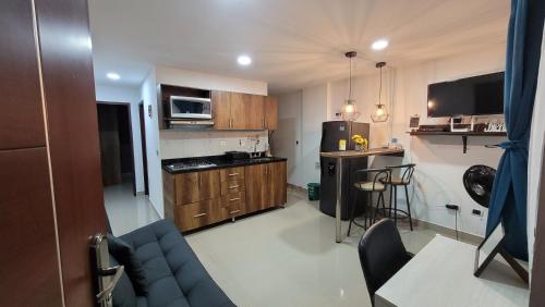 a small kitchen with wooden cabinets and a blue couch at ANDALIVING NIQUIA Apartaestudio in Bello