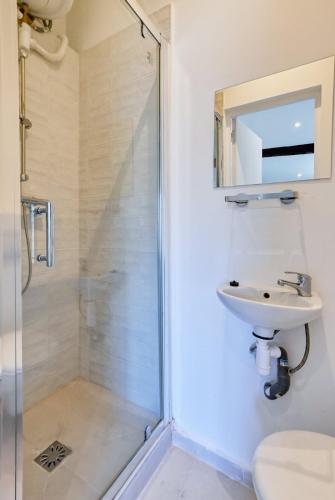 une salle de bain avec douche et lavabo dans l'établissement charmant studio climatisé pres de notre dame de la garde, à Marseille