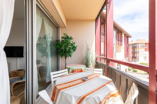 un balcon avec une table et des chaises sur un balcon dans l'établissement Hossegor - Piscine - Parking - Plage - Couple, à Hossegor