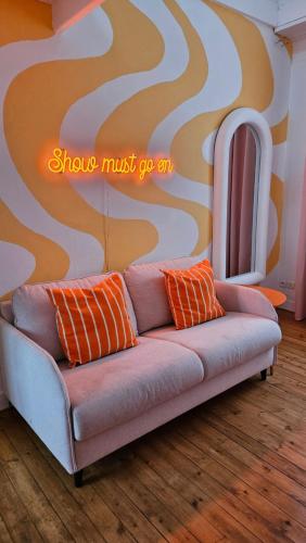 - un canapé dans le salon avec un mur dans l'établissement Appartement coloré proche du centre ville et de la gare, à Deauville