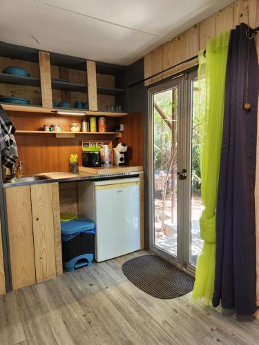 une cuisine avec un comptoir et une porte coulissante en verre dans l'établissement Les Animaux et Marino, à Saint-Andiol