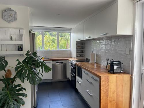 a kitchen with white cabinets and a counter top at Chic Whangarei Retreat, walk to CBD in Whangarei