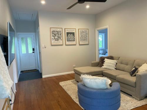 a living room with a couch and a blue chair at Chic Whangarei Retreat, walk to CBD in Whangarei